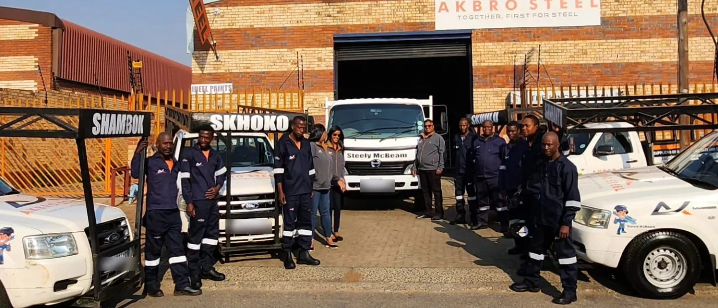 The Akbro team in front of the store under the AKBRO STEEL sign